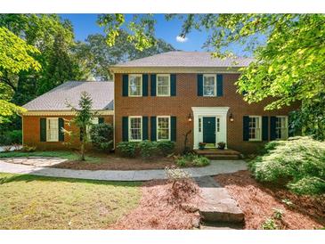 Charming two-story brick home with manicured lawn and mature trees creating a welcoming curb appeal at 2144 Lamplight Dr, Marietta, GA 30062