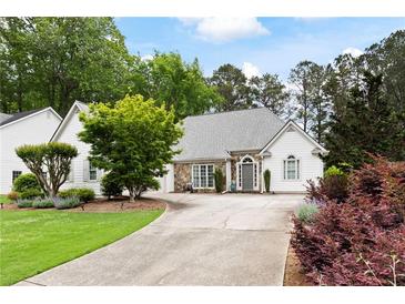 Charming home featuring a stone and siding facade, well-manicured lawn, and a welcoming driveway at 5042 Southland Dr, Woodstock, GA 30188