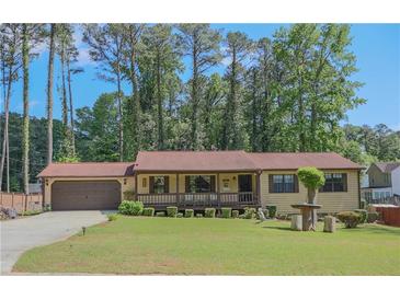 Ranch style home with a covered porch, large front yard, and an attached two car garage at 3814 Lamar Way, Snellville, GA 30039