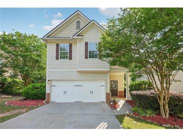 Charming two-story home with a well-manicured lawn, attached garage, and inviting front porch at 6071 Apple Grove Rd, Buford, GA 30519