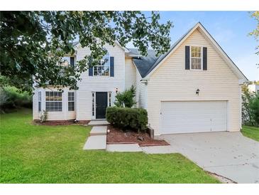 Charming two-story home featuring a well-manicured lawn and a two-car garage, creating an inviting curb appeal at 137 Legend Creek Dr, Canton, GA 30114