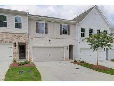 Townhome exteriors featuring painted brick, siding, manicured lawns, and two car garages at 4655 Larkfield Way, Powder Springs, GA 30127
