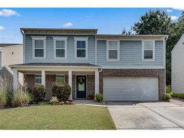 Charming two-story home featuring a covered porch, a brick facade, and a two-car garage at 5437 Blossom Brook Dr, Sugar Hill, GA 30518