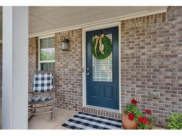 Charming brick home featuring a welcoming blue front door adorned with a decorative wreath at 5437 Blossom Brook Dr, Sugar Hill, GA 30518