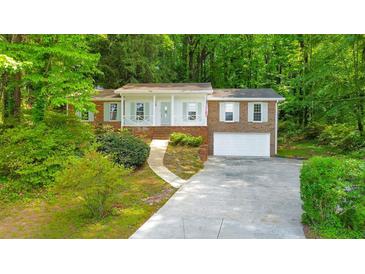 Charming single-story brick home featuring a well-manicured front yard, and a two-car attached garage at 1584 Allgood Ne Rd, Marietta, GA 30062