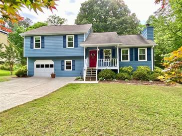 Charming blue split-level home featuring a red front door and well-maintained landscaping at 5364 Muirwood Pl, Powder Springs, GA 30127