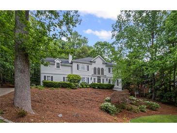 Elegant two-story home featuring a well-manicured lawn and professional landscaping at 7750 Landowne Dr, Atlanta, GA 30350