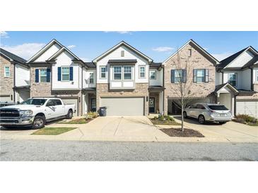 Attractive townhomes featuring a two-car garage and a mix of stone and siding exterior at 1388 Ben Park Way, Grayson, GA 30017