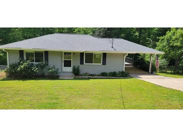Charming single story home with a well maintained lawn, beautiful shrubbery, and convenient covered parking at 3844 Davis St, Suwanee, GA 30024