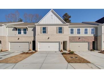 Charming townhome with a two-car garage and brick and siding facade, set on a sunny day at 4525 Twinberry Dr, Powder Springs, GA 30127