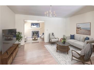 Bright living room features hardwood floors, neutral paint, modern furniture, and a smooth transition to a living space at 143 Lablanc Nw Way, Atlanta, GA 30327