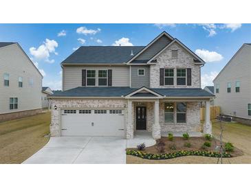 Charming two-story home featuring a brick and siding exterior, covered porch, and two-car garage at 553 Princeton Elm Place Way, Lawrenceville, GA 30045