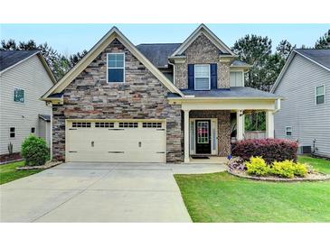 Charming two-story home with a stone and brick facade, two-car garage, and well-maintained landscaping at 6468 Pierless Ave, Sugar Hill, GA 30518