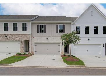 Charming townhomes with brick and siding exteriors, two-car garages, and well-manicured lawns create inviting curb appeal at 4659 Larkfield Way, Powder Springs, GA 30127