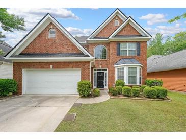 Charming two-story brick home featuring a well-manicured lawn and attached two-car garage at 7979 Larksview Dr, Fairburn, GA 30213