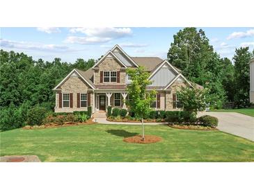 Beautiful home with manicured lawn, stone facade, dormer windows, and inviting entryway at 125 Registry Ln, Canton, GA 30115