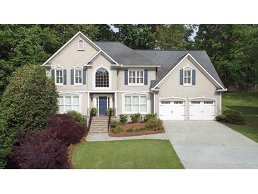 Charming two-story home features an attached two-car garage, and a beautifully landscaped yard with mature trees at 4314 Woodhaven Se Way, Smyrna, GA 30082