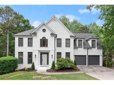 Beautiful two-story home featuring white brick, black window trim, attached two-car garage and landscaped front yard at 4294 Silver Peak Pkwy, Suwanee, GA 30024