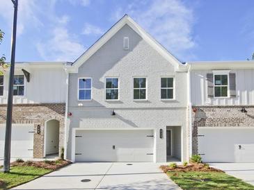 Charming townhome featuring a painted brick facade, attached garage, and manicured landscaping at 4651 Larkfield Way, Powder Springs, GA 30127