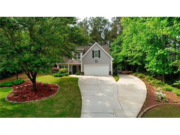 Charming home featuring a well-manicured front yard and a long driveway, nestled among mature trees at 95 Loudoun Dr, Covington, GA 30014
