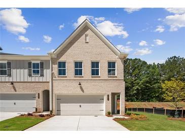 Charming new construction townhouse with a brick facade, well-manicured lawn, and attached garage at 4671 Larkfield Way, Powder Springs, GA 30127