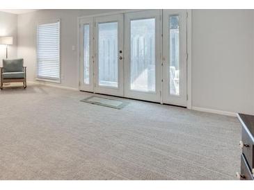 Bright living room with sliding doors, large windows, and neutral carpet at 6851 Roswell Rd # H1, Sandy Springs, GA 30328