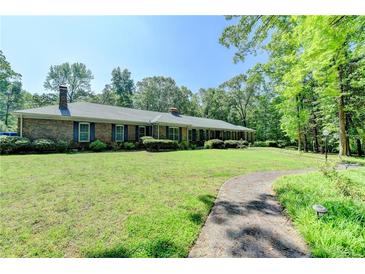 Charming brick ranch-style home with a sprawling lawn and mature trees offering a tranquil and inviting curb appeal at 168 Woodland Valley Rd, Lawrenceville, GA 30046