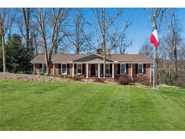Charming brick ranch home with manicured lawn, mature trees, and welcoming front porch at 3250 North Embry Cir, Chamblee, GA 30341
