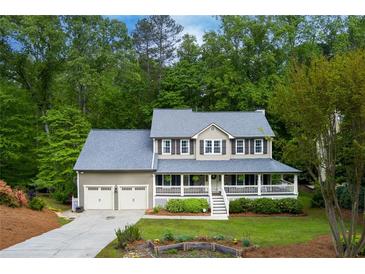 Charming two-story home with a welcoming front porch and attached two-car garage surrounded by lush trees at 2249 Hill Creek Way, Marietta, GA 30062