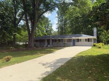 Charming single-story home with a brick facade, mature trees, and a long driveway at 2463 Briarmoor Ne Rd, Atlanta, GA 30345
