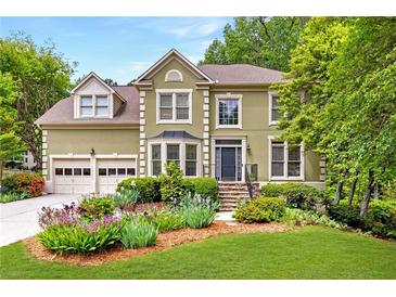 Charming two-story home with a well-manicured lawn, stone stairs, and beautifully landscaped front yard at 10540 Waters Ridge Dr, Alpharetta, GA 30022