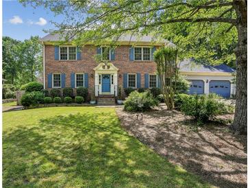 Charming two-story brick home with blue shutters and a well-manicured front yard at 3322 Woodsfield Ne Dr, Marietta, GA 30062