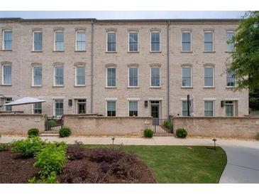 Stylish townhouse exterior featuring a brick facade, manicured lawn, and inviting entryway at 3433 Landen Pine Ne Ct, Atlanta, GA 30305