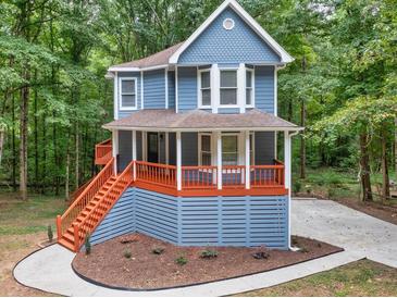 Charming two-story home with a covered porch and eye-catching curb appeal, nestled in a serene wooded setting at 1310 Ridgeview Rd, Auburn, GA 30011
