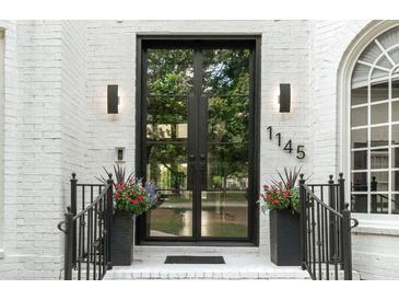 Elegant home entrance featuring a modern black framed glass double door and black metal railings at 1145 Lake Shore Overlook, Alpharetta, GA 30005