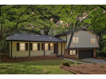 Charming home featuring a covered front porch, manicured lawn and attached garage at 218 Deerwood Se Ct, Smyrna, GA 30082
