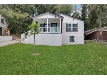 Charming two-story home with landscaped yard and covered front porch; a welcoming facade at 235 Holly Nw Rd, Atlanta, GA 30314