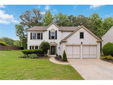 Charming two-story home with a manicured front yard and a two-car garage at 1931 Abinger Way, Lawrenceville, GA 30043