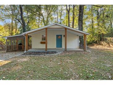 Charming single-story home with a covered front porch and bright blue front door surrounded by mature trees at 2917 Reveille Se Cir, Atlanta, GA 30316