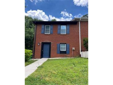 Charming two-story townhome with brick facade, blue shutters and a well-maintained lawn at 1001 Park Gate Pl, Stone Mountain, GA 30083