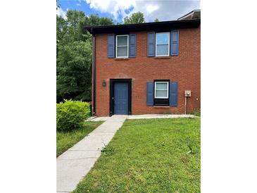Charming brick townhouse featuring blue shutters and a neatly maintained front lawn at 1001 Park Gate Pl, Stone Mountain, GA 30083