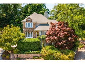 Charming home with stone accents, complemented by mature trees and lush landscaping at 1077 Shady Valley Ne Pl, Atlanta, GA 30324