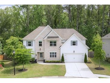 Beautiful two-story home with a brick and siding exterior, complemented by a well-manicured lawn and mature trees at 572 Cresentry Brk, Smyrna, GA 30082