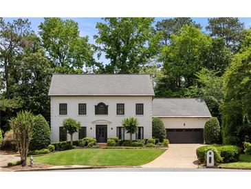 Charming two-story home with manicured lawn, mature trees, and attached two-car garage at 2180 Dunwoody Heritage Dr, Atlanta, GA 30350
