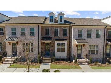 Charming townhomes boast brick exteriors with black accents and well-manicured lawns at 3239 Bartee Walk, Suwanee, GA 30024