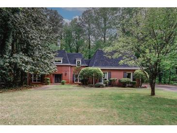 Charming brick home with manicured lawn and mature trees provides great curb appeal at 110 Vistacrest Way, Roswell, GA 30075