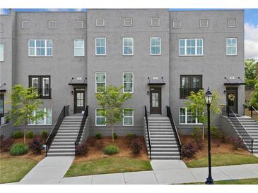 Modern townhome with brick facade, manicured landscaping, and inviting stairways to each unit's private entrance at 244 Church St, Lawrenceville, GA 30046