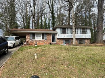 Charming two-story brick home with a front yard, carport, and shuttered windows at 8474 Magnolia Dr, Jonesboro, GA 30238