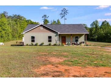 Charming single-story home with a covered front porch, green siding, and well-maintained landscaping at 130 Williams Rd, Villa Rica, GA 30180