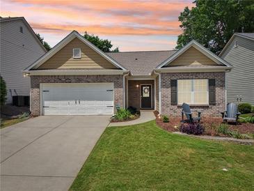 Charming brick home with a well-manicured lawn, two-car garage, and inviting front porch at 409 Norton Xing, Woodstock, GA 30188